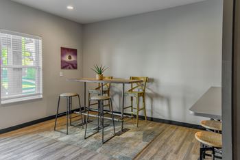a dining area with a table and chairs and a window